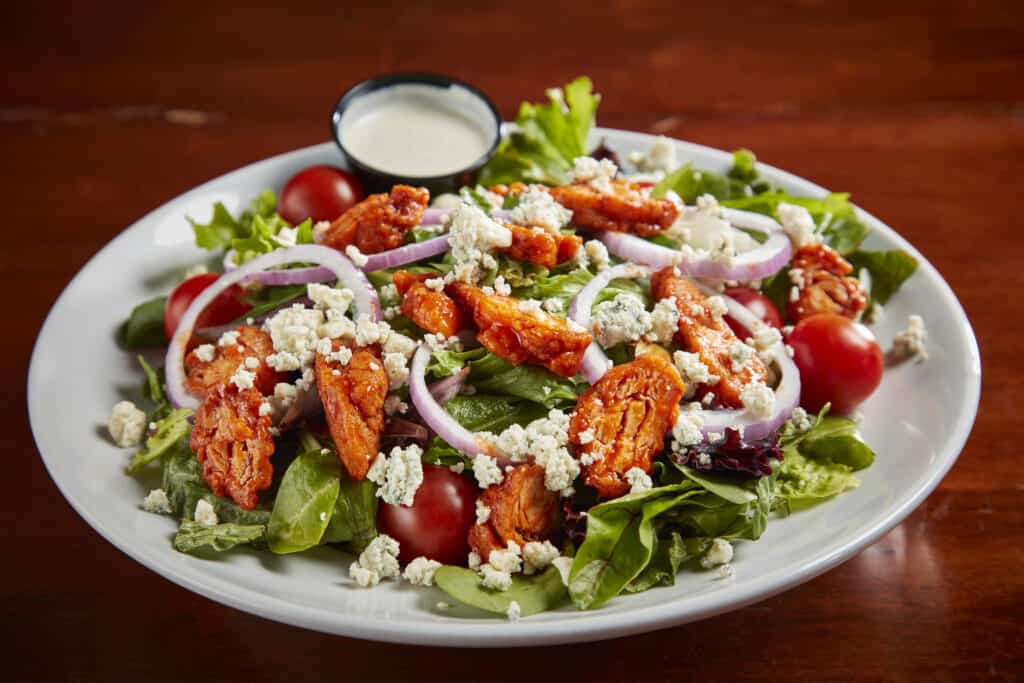 Romaine and spring mix with boneless buffalo chicken, red onion, grape tomatoes, celery leaves, blue cheese crumbles. With ranch or blue cheese dressing. $16.99