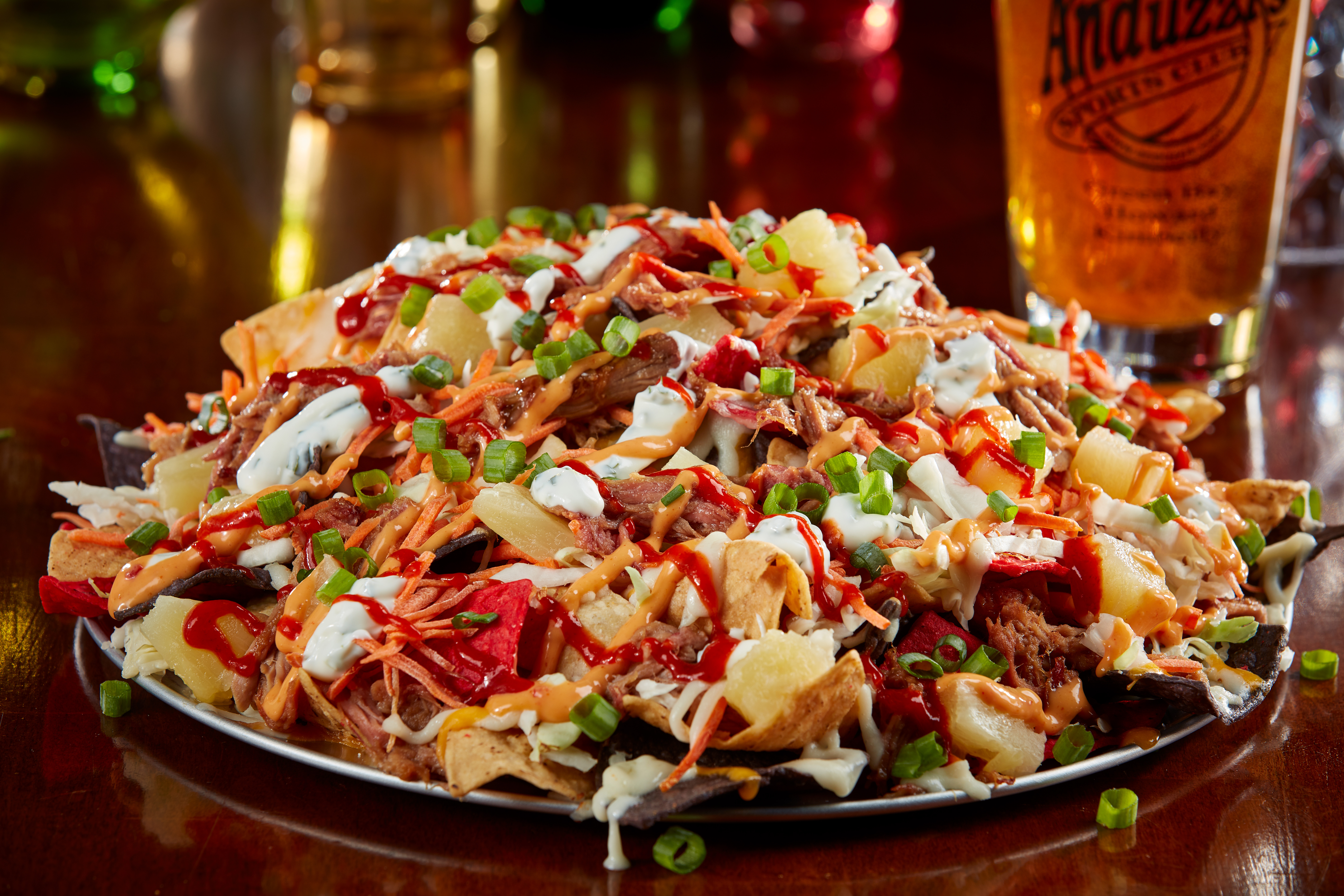 Tortilla chips topped with teriyaki pulled pork, shredded cabbage, carrots, green onion, pineapple, melted cheese and drizzled with cilantro lime sour cream, bang-bang sauce and Sriracha. $18.99