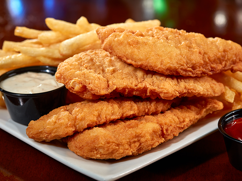 Chicken tenders on a plate with fries and dip
