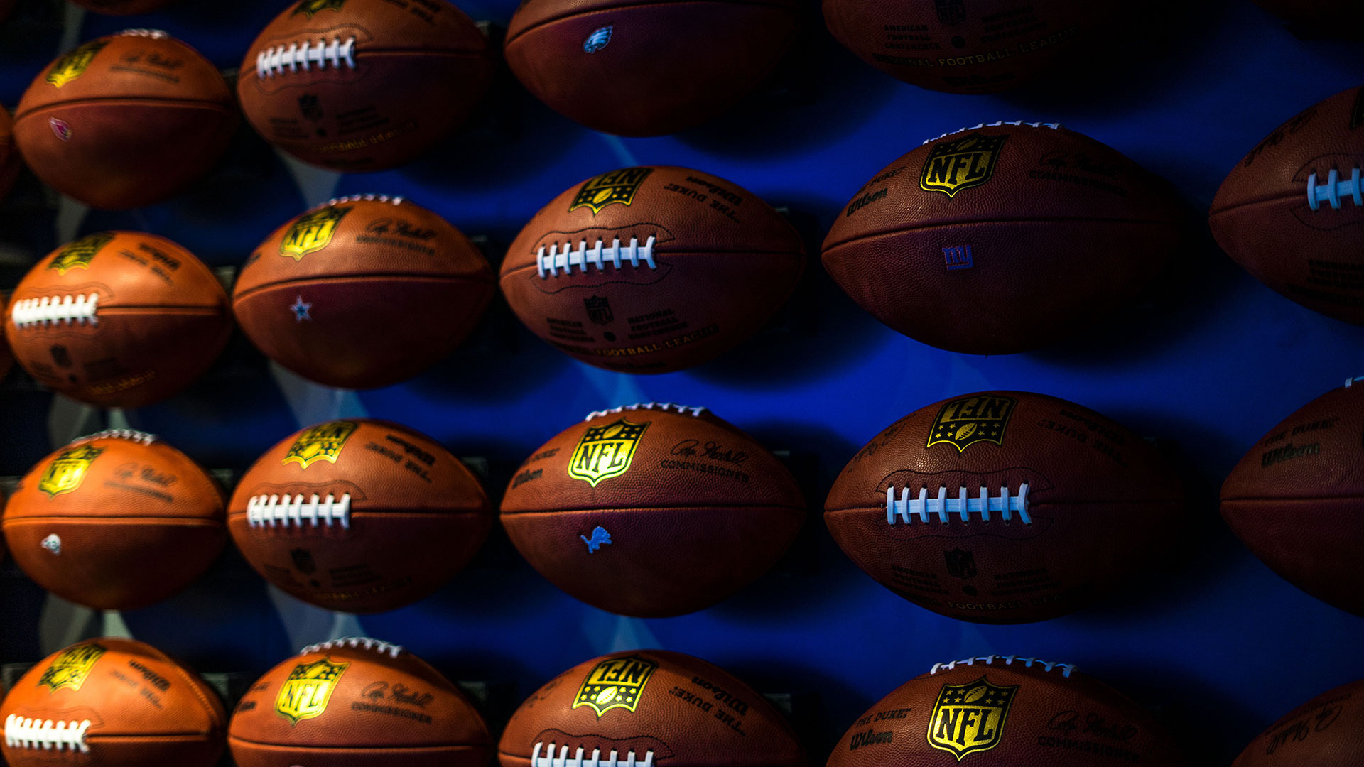 Footballs on a wall with a blue background